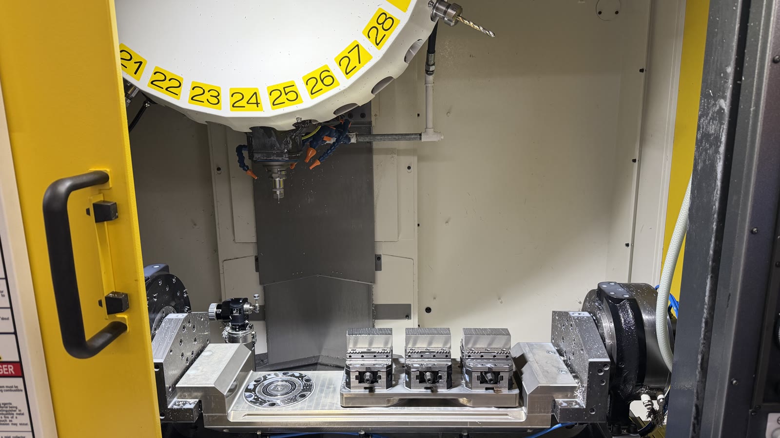 FANUC ROBODRILL work area with three parts clamped in vises at CNC Plus