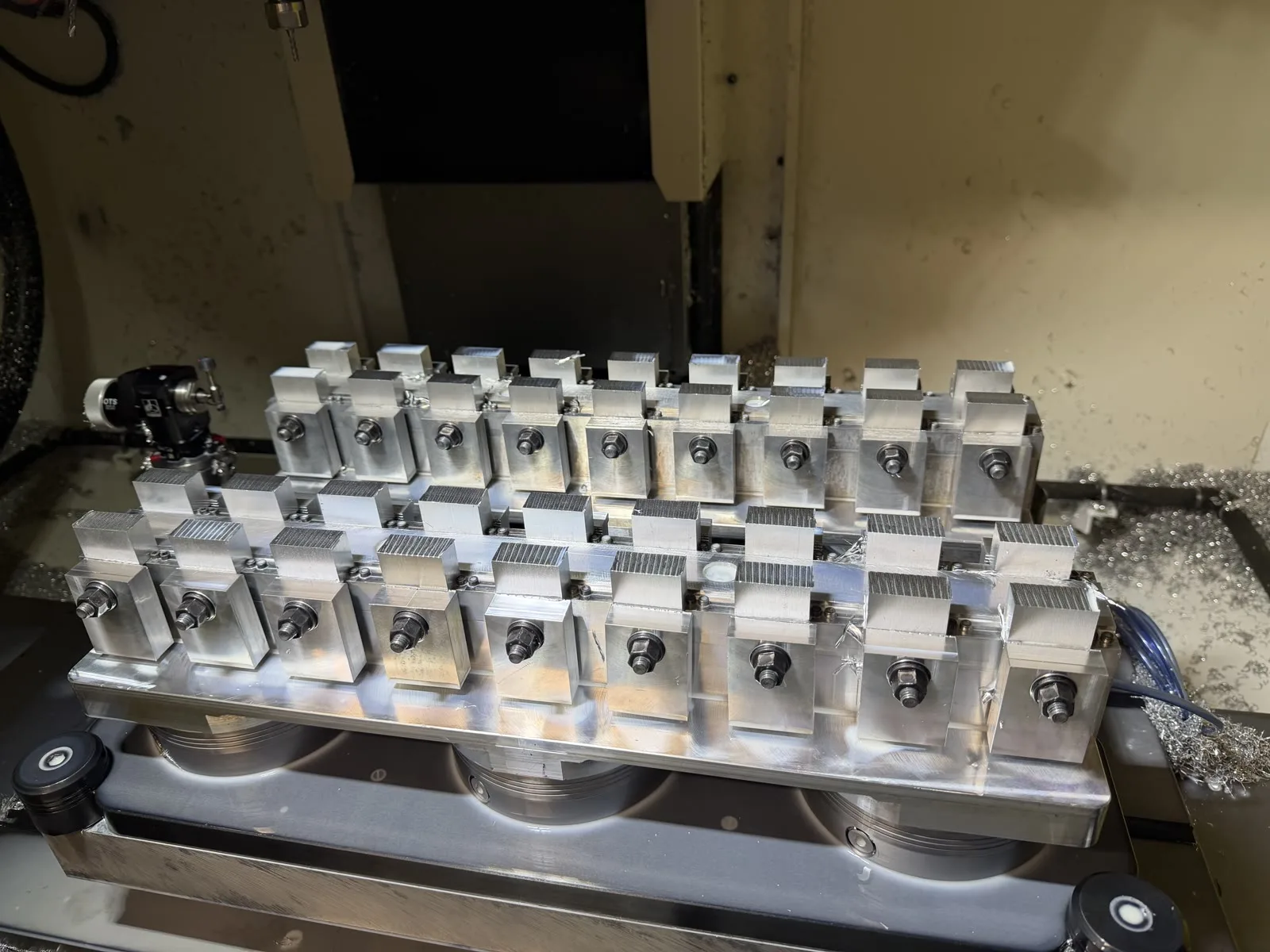 Production fixture holding rows of partially machined aluminium parts inside a FANUC ROBODRILL
